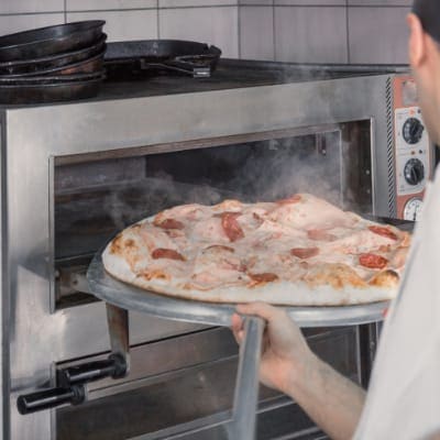 making pizza in a pizza oven